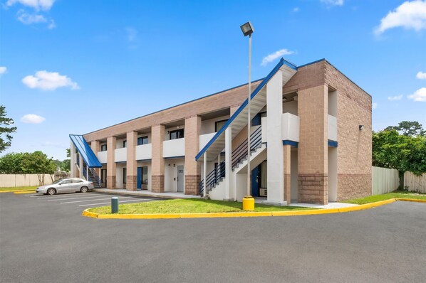 A multi-story parking garage with a modern design, featuring a central staircase and a covered entrance.