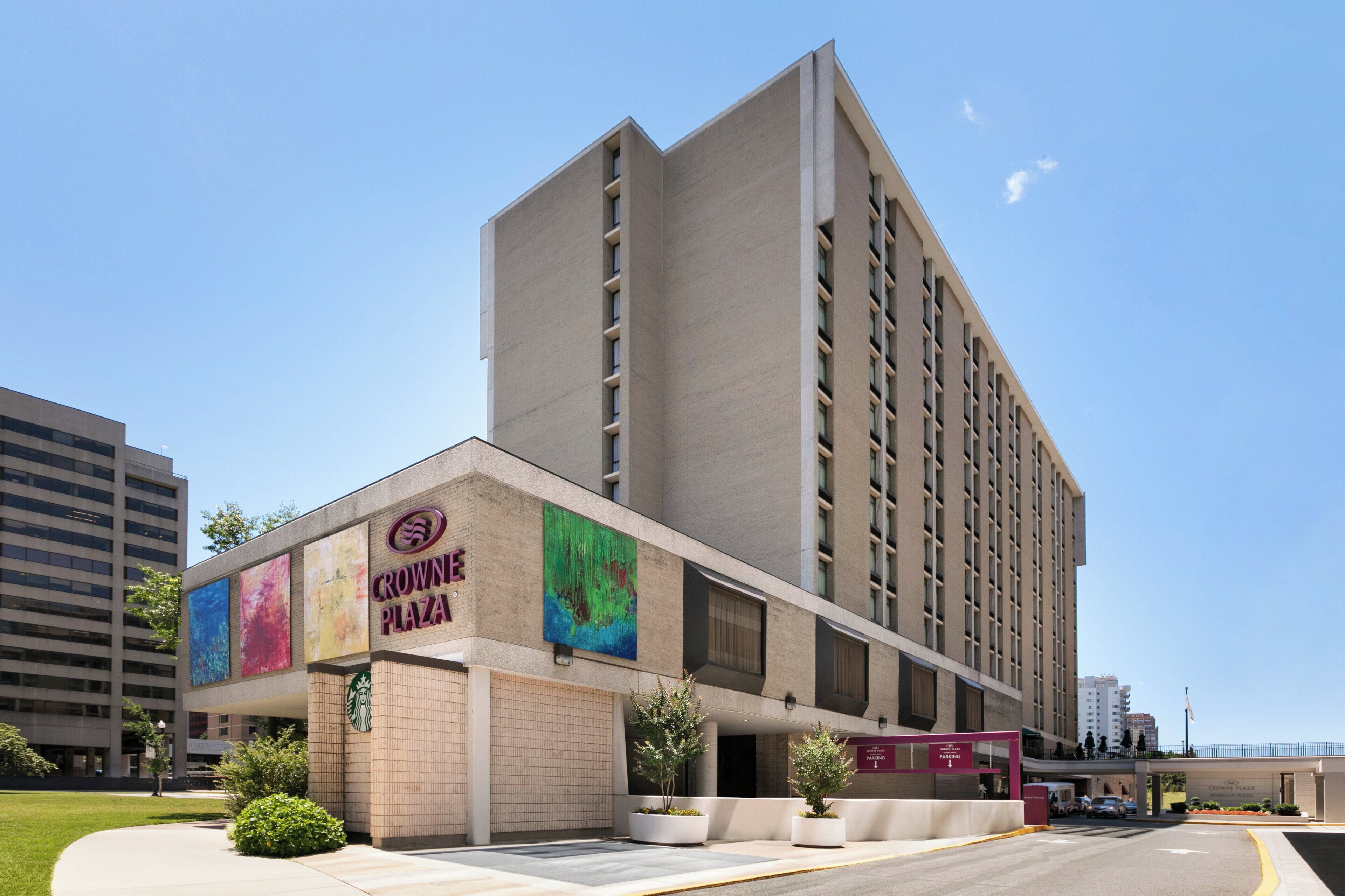 Un hôtel à plusieurs étages, reconnaissable à son enseigne bien visible indiquant « Crown Plaza ».