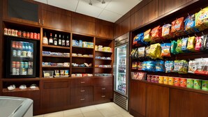 Un rayon bien garni de collations et de boissons, avec une variété de produits emballés et d’aliments réfrigérés.