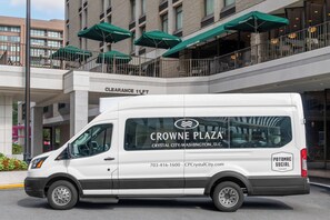 A white van parked in front of a building with green umbrellas and a sign that reads "CLEARANCE 11 FT". - Crowne Plaza Crystal City-Washington, D.C. by IHG (Arlington)