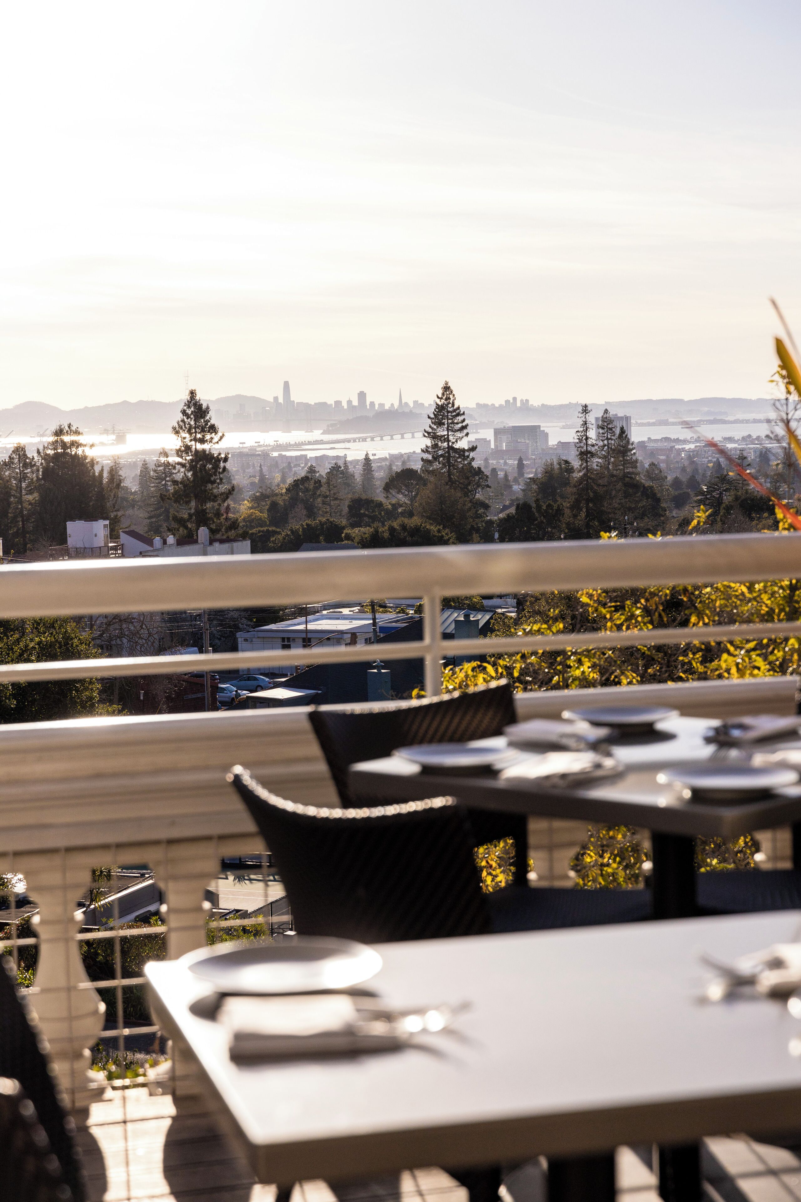 A restaurant with outdoor seating overlooking a cityscape.