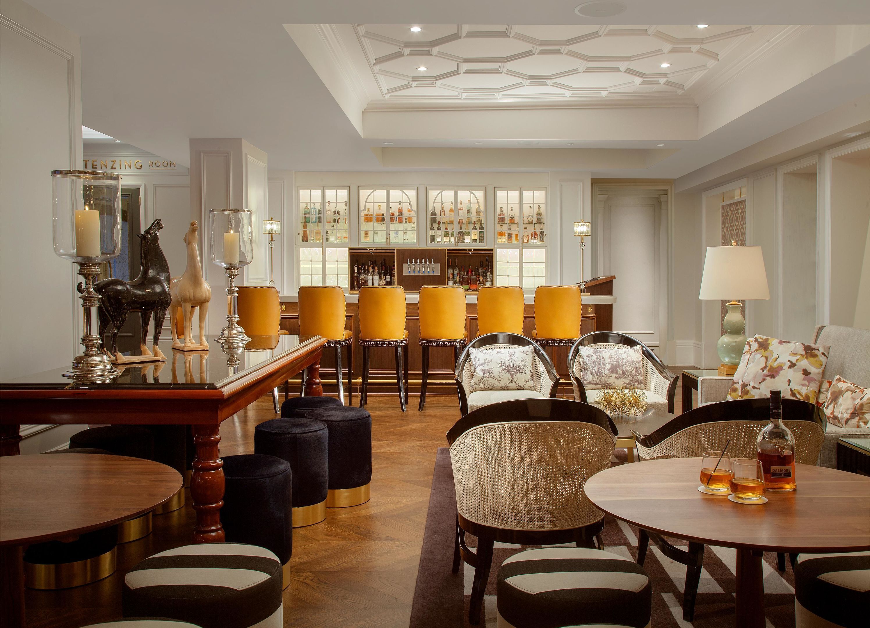 A bar area with a display of liquor bottles, a bar counter, and seating arrangements.