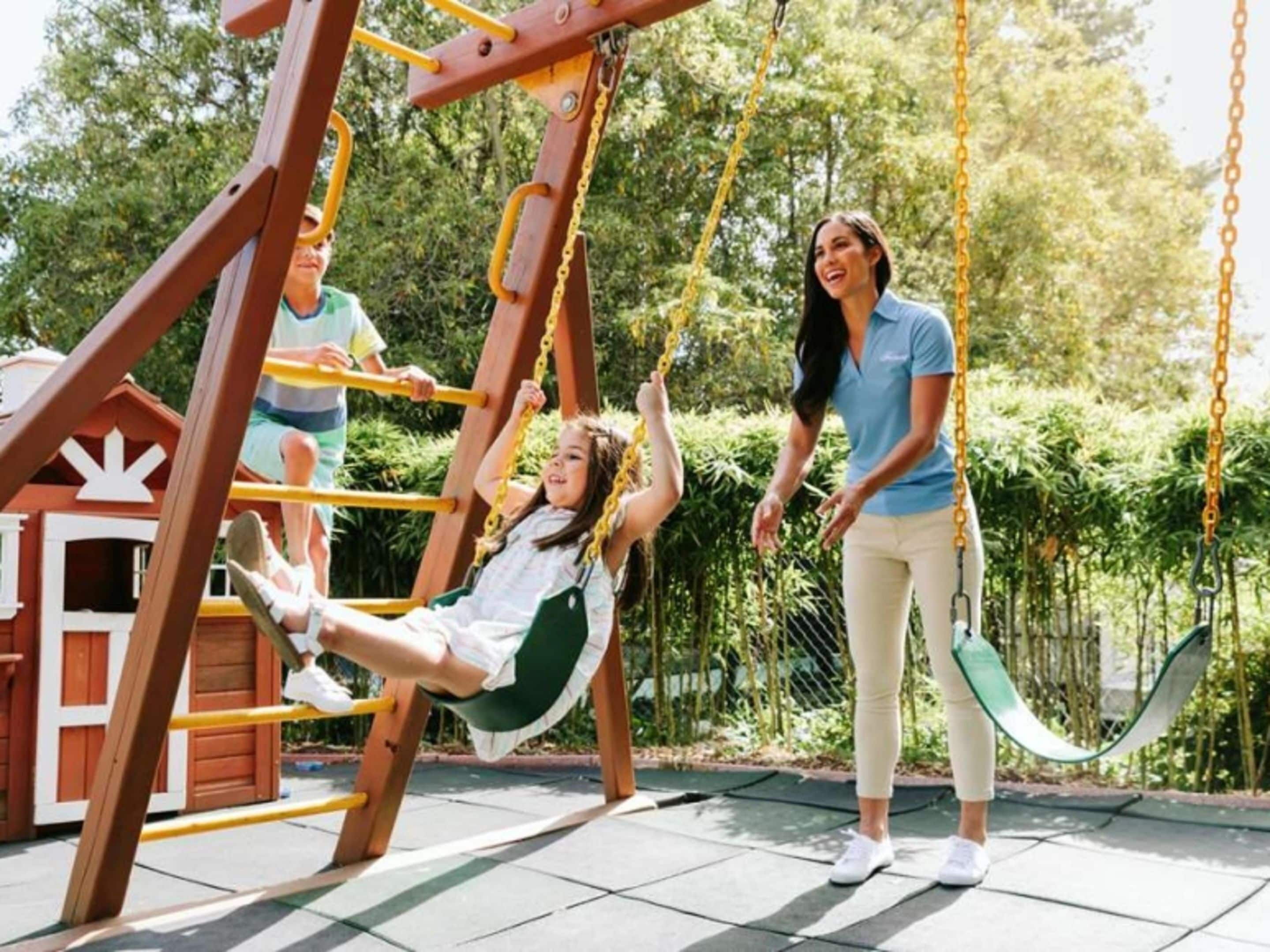 Un parque infantil con columpios y una casita de juegos.