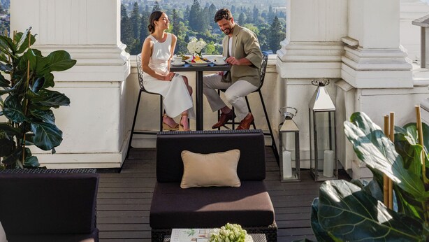 A terrace with a view, featuring a table and chairs, a potted plant, and a decorative lantern. - Claremont Resort & Club (Berkeley)
