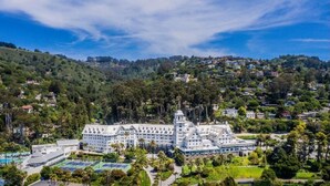 A large, white hotel with multiple wings and a central tower, surrounded by lush greenery and hills. - Claremont Resort & Club (Berkeley)