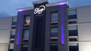 A Sleep Inn hotel with a modern facade, featuring a prominent sign and illuminated windows.
