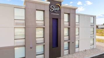 Edificio de Sleep Inn, una marca de Choice Hotels, con un diseño moderno, grandes ventanales y una entrada destacada.