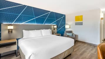 Habitació d'hotel amb un llit gran, taules de nit, escriptori i una cadira.
