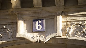 A stone building with a carved number '6' on a blue plaque.