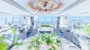 Un comedor moderno con mesas redondas, sillas grises y un arreglo floral central.