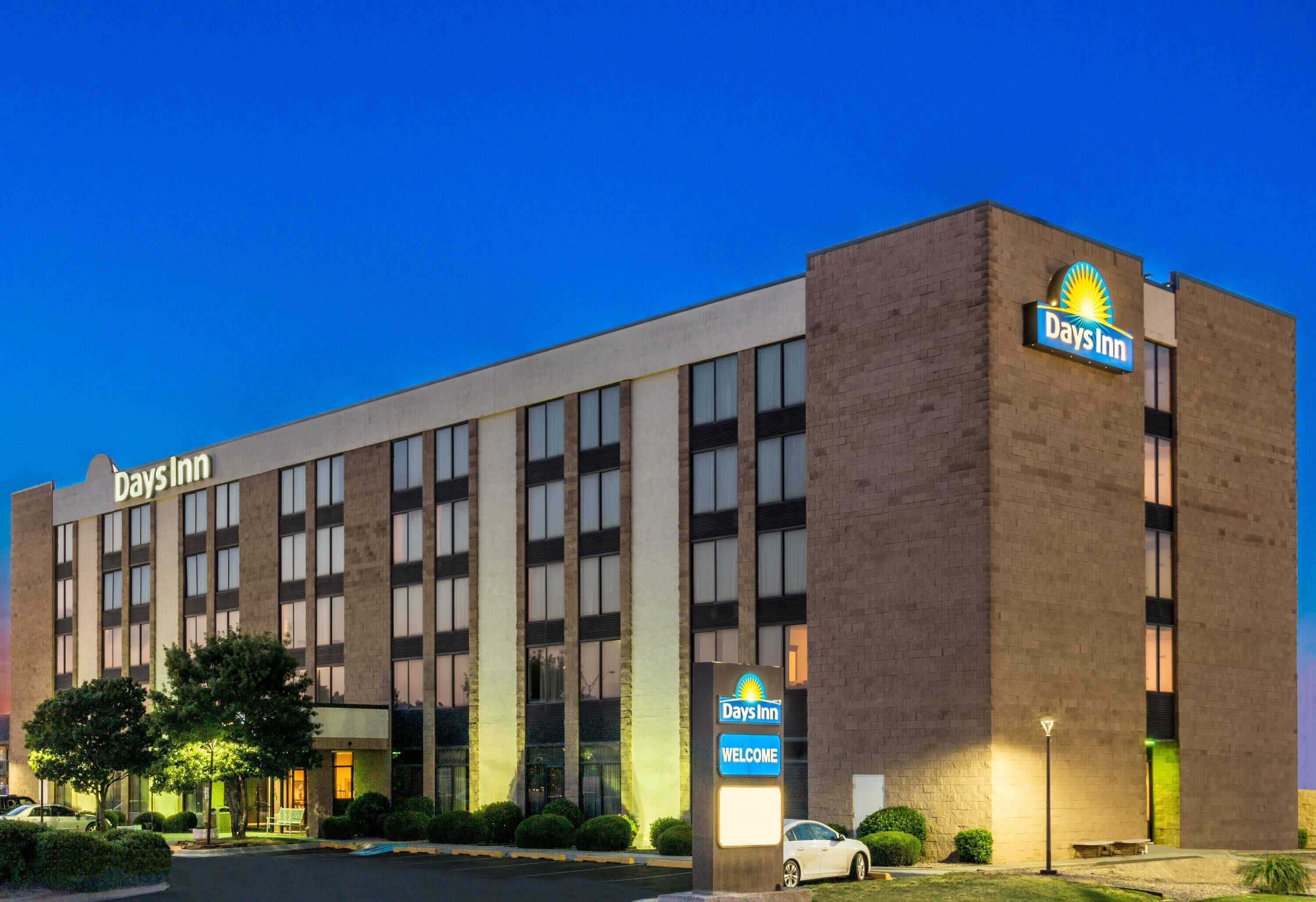 Edificio del hotel Days Inn con un cartel llamativo, ventanas amplias y una entrada bien iluminada.