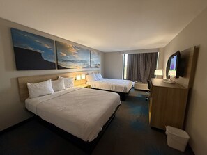A hotel room with two beds, a desk, a television, and artwork on the walls. - Days Inn by Wyndham Amarillo East (Amarillo)