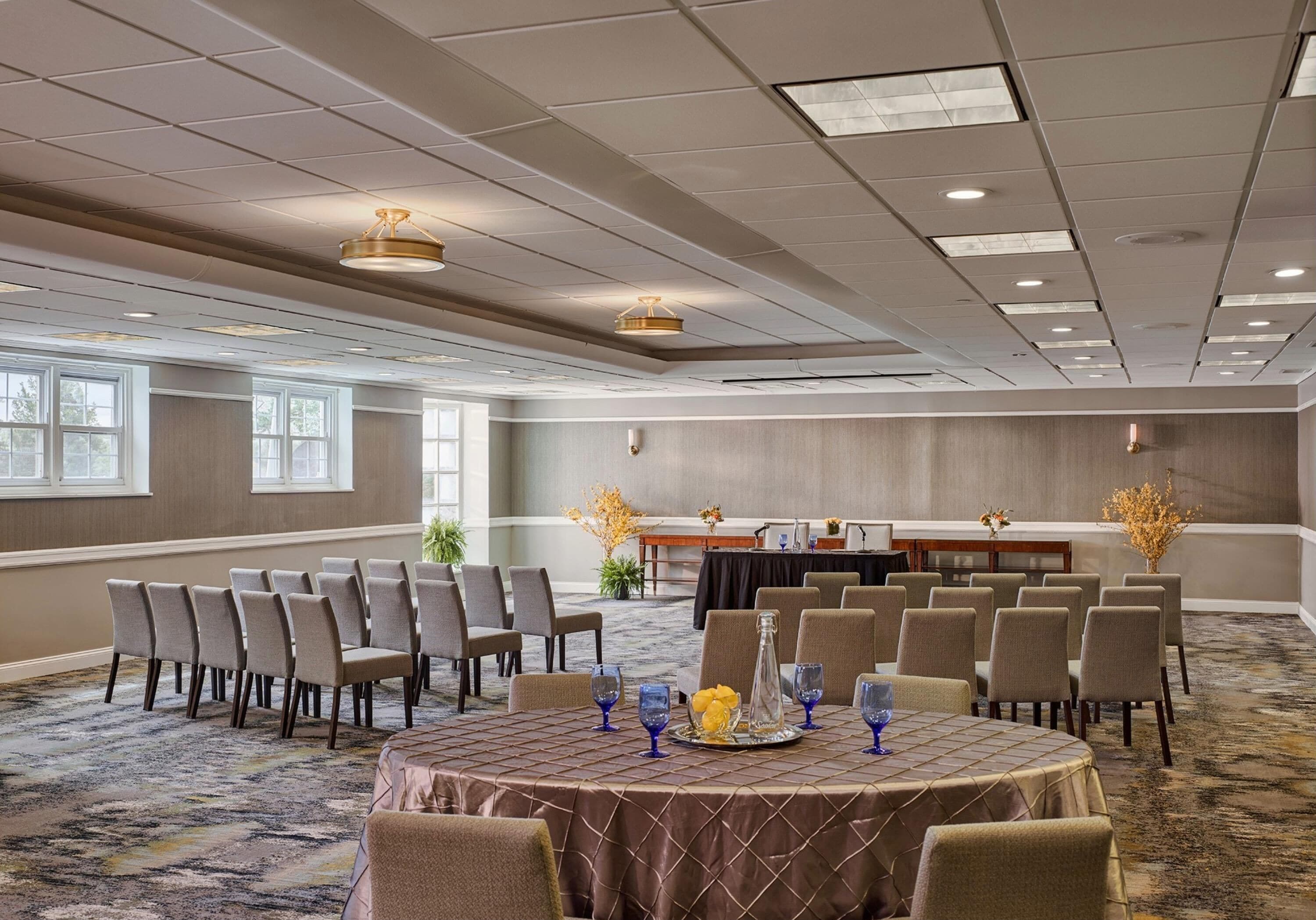 A conference room with a round table, chairs, and a buffet setup.