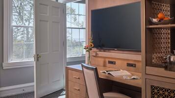 A study room with a desk, chair, and a large flat-screen TV.