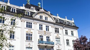 Un bâtiment historique, reconnaissable à son imposante enseigne « HÔTEL ROYAL », à son architecture classique et à un drapeau qui flotte au sommet.