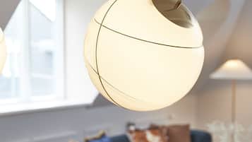 A modern dining area with a round table, chairs, and a hanging light fixture.