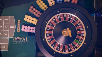 A roulette wheel and chips on a casino table.