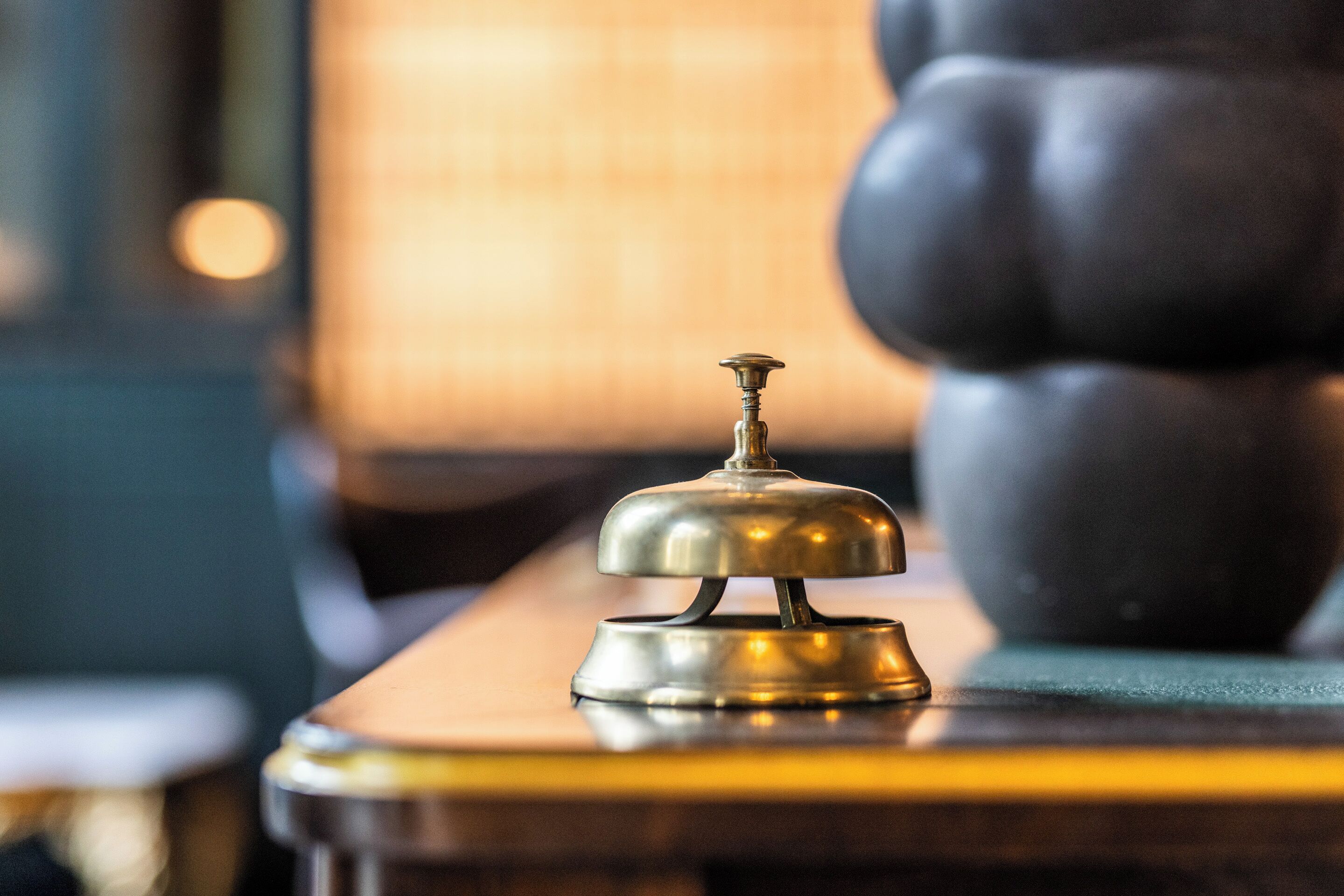 Una campana de bronce sobre una superficie de madera, probablemente en una habitación de hotel.