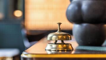 Una campana de bronce sobre una superficie de madera, probablemente en una habitación de hotel.