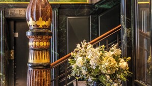 Un escalier en marbre agrémenté d’une balustrade décorative et d’une composition florale.