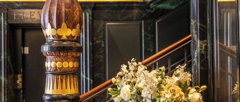 A marble staircase with a decorative balustrade and a floral arrangement.