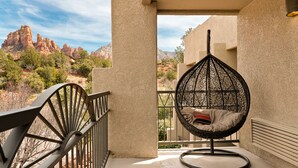 A balcony with a hanging chair overlooking a mountainous landscape. - Arabella Hotel Sedona (Sedona)