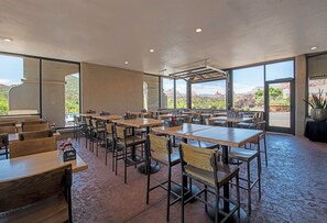An indoor dining area with tables and chairs, large windows, and a view of a mountainous landscape. - Arabella Hotel Sedona (Sedona)