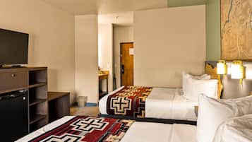 A hotel room with two beds, a TV, a wooden desk, and a map on the wall.