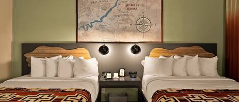 Habitación de hotel con dos camas, un escritorio y un mapa en la pared.