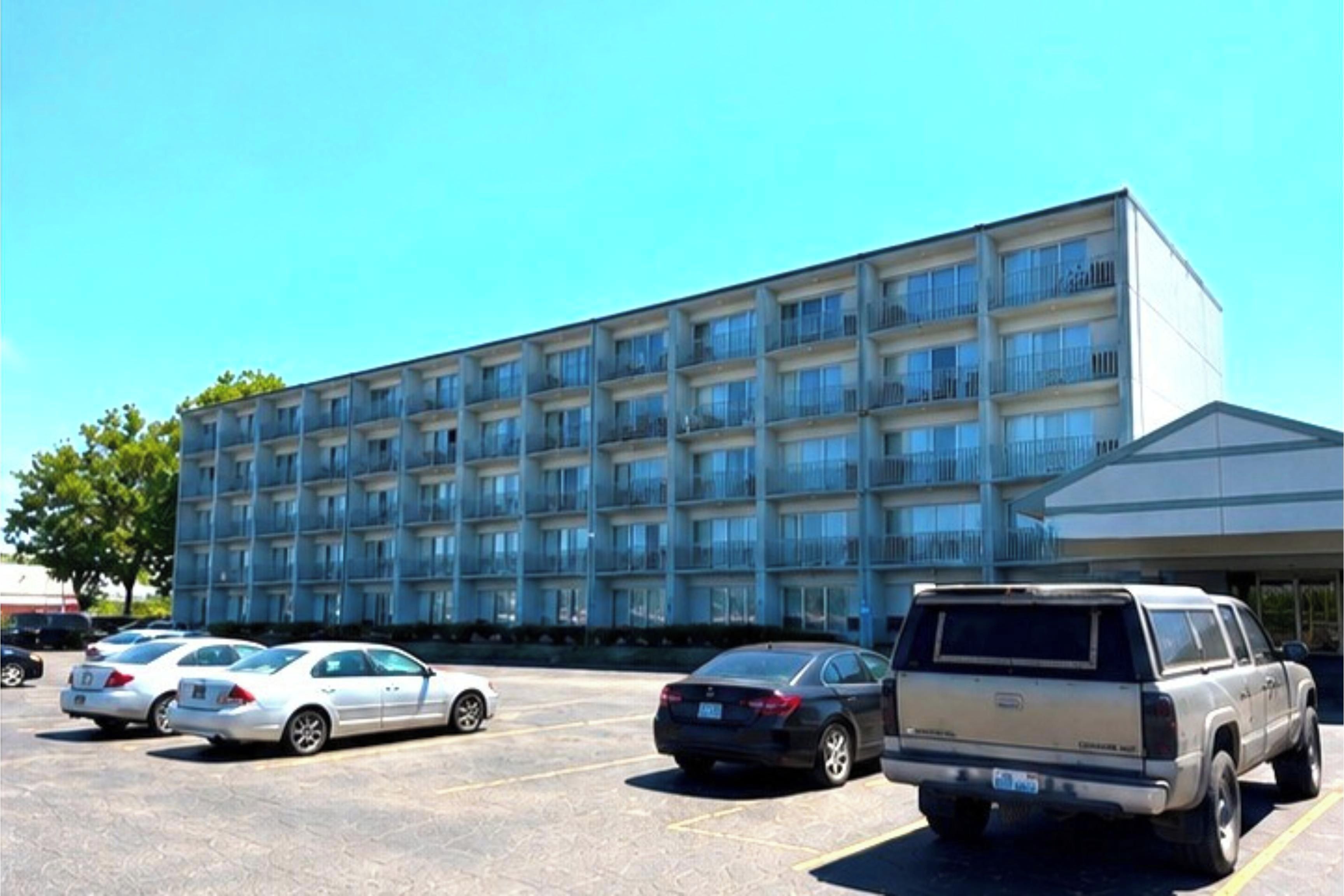 Un hôtel à plusieurs étages avec un parking situé à l’avant.