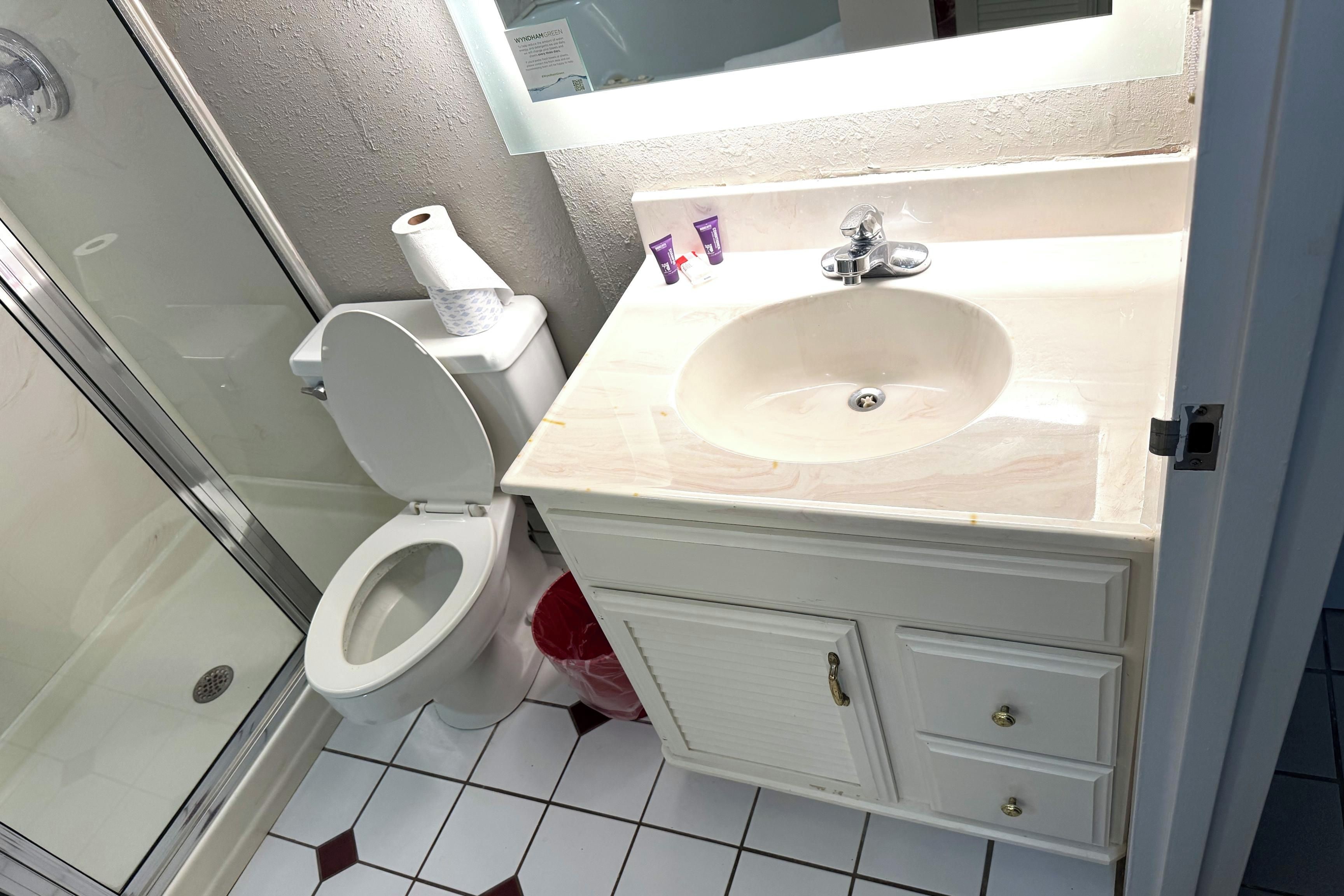A bathroom with a toilet, sink, and shower.