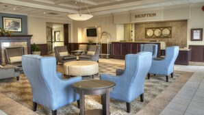 A lobby with a reception desk, seating area, and a fireplace.