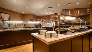A buffet area with multiple food stations, including a salad bar and a pastry display.