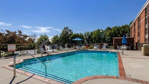 A clear blue pool with a no diving sign, surrounded by lounge chairs and umbrellas, with a brick building in the background. - Comfort Inn Blacksburg University Area (Christiansburg)