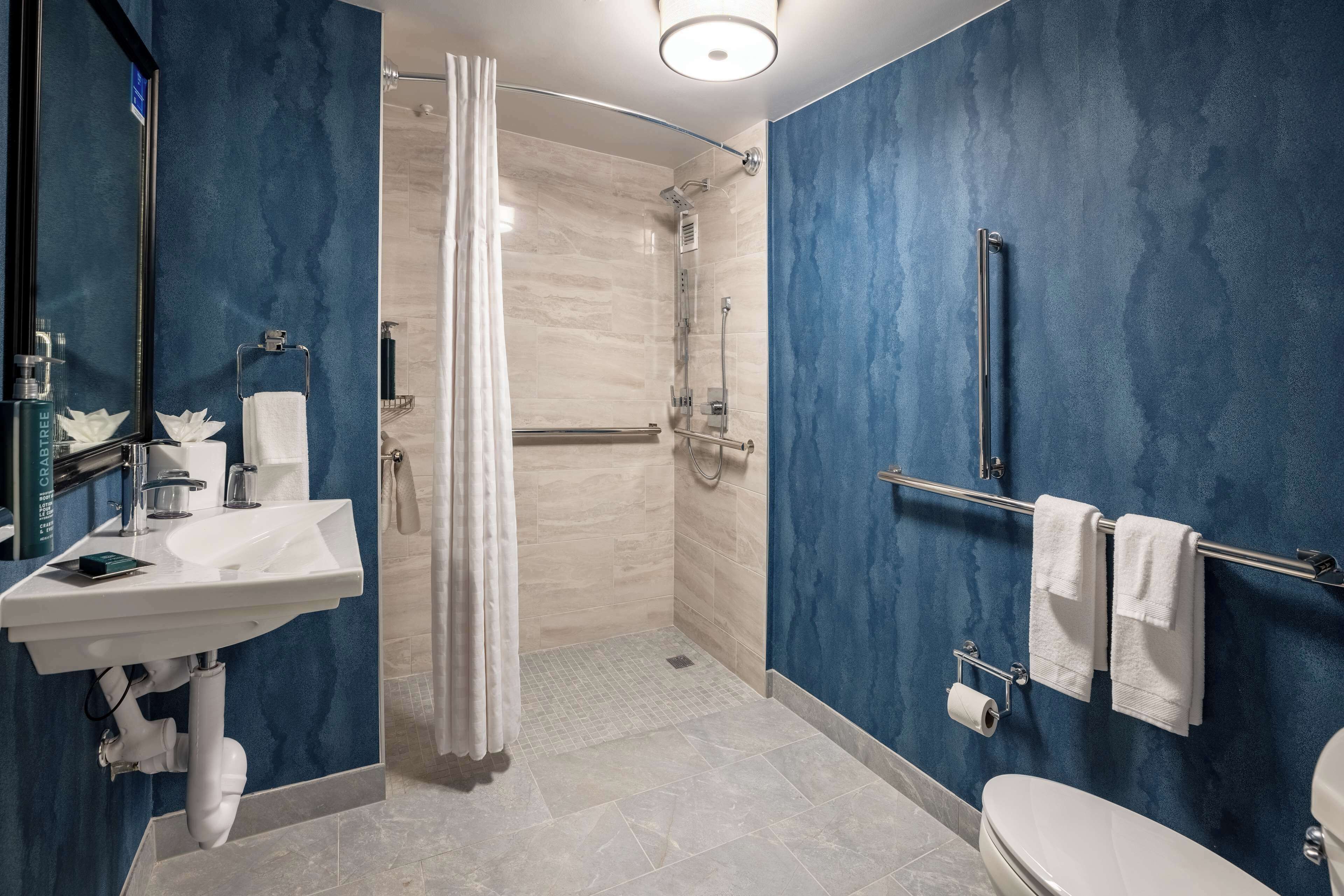 Une salle de bain moderne équipée d’une douche, de toilettes et d’un lavabo.