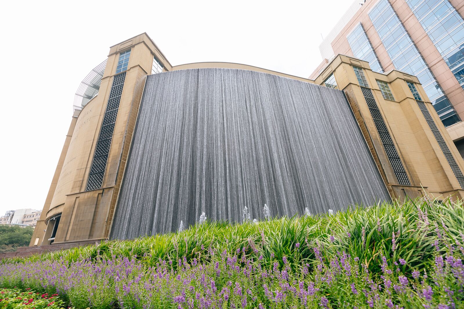 A large building with a waterfall feature in front.
