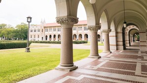 A covered walkway with arches and columns, leading to a building with a red roof. - DoubleTree by Hilton Houston Medical Center Hotel & Suites (Houston)