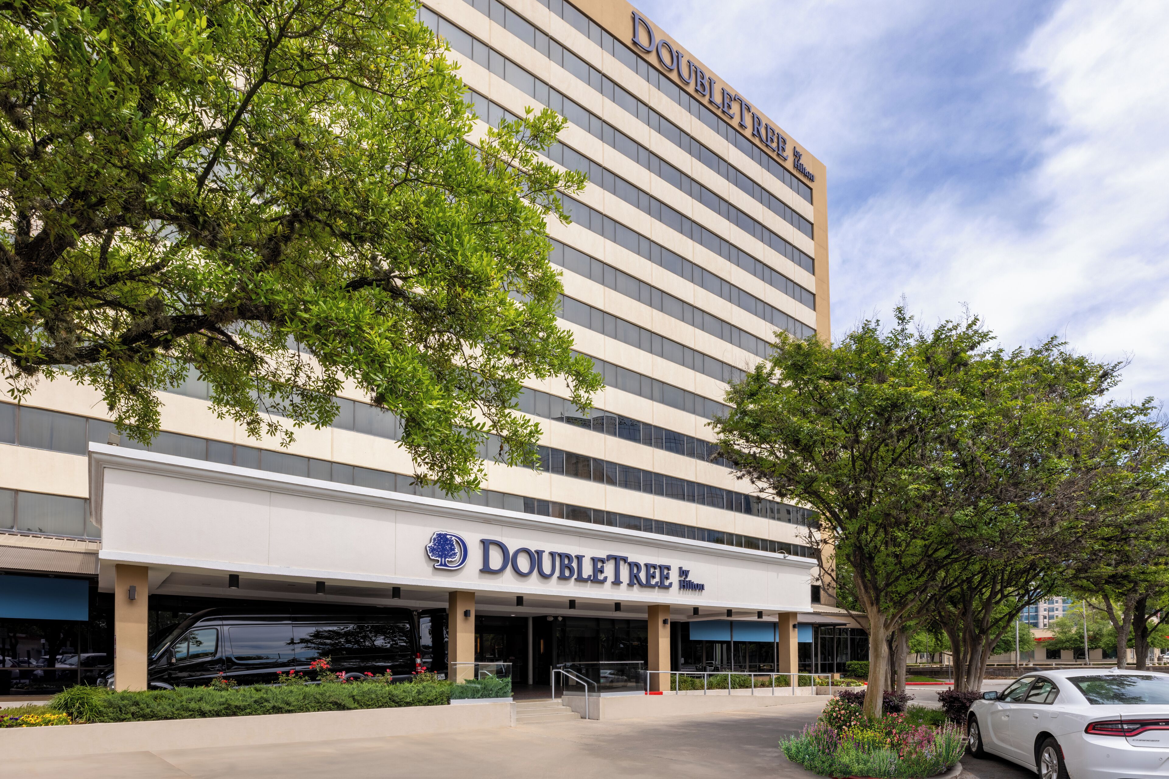 A DoubleTree hotel with a modern facade, large windows, and a covered entrance area.