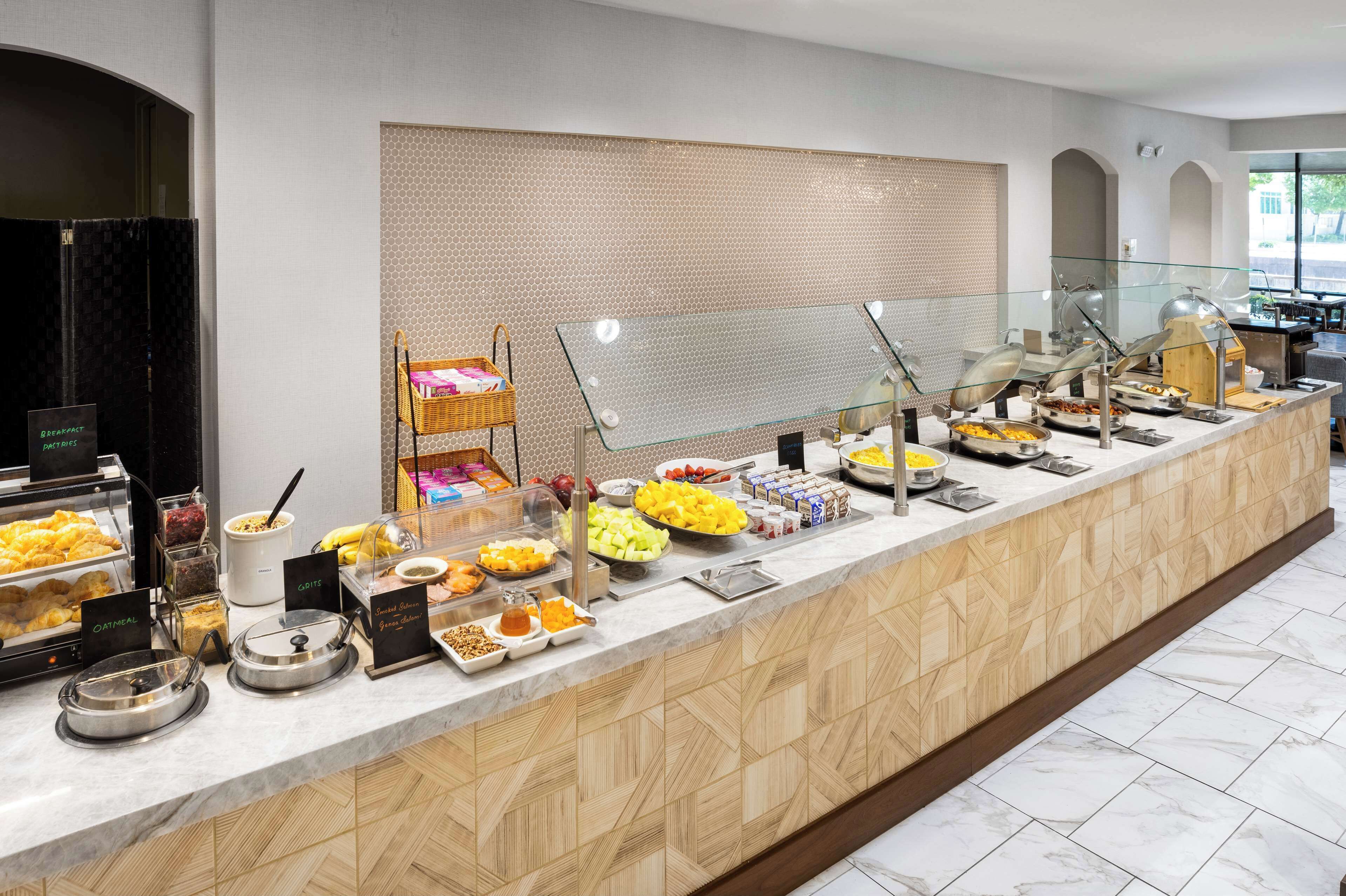 A buffet with various food items and a wicker basket.