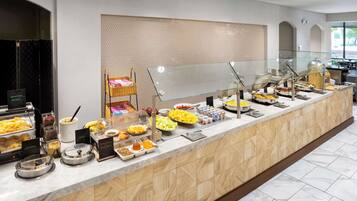 A buffet with various food items and a wicker basket.