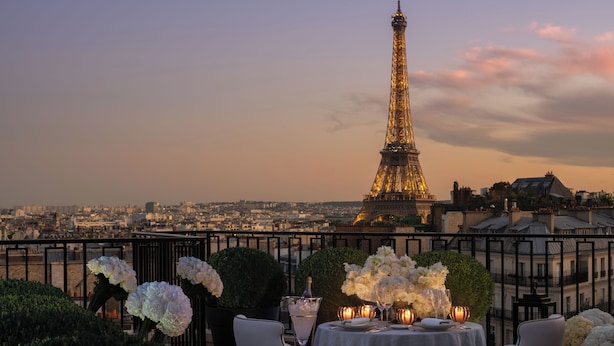 Mesa lista para comer con vista a la Torre Eiffel al fondo.