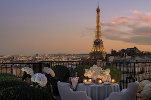 A table set for dining with a view of the Eiffel Tower in the background.