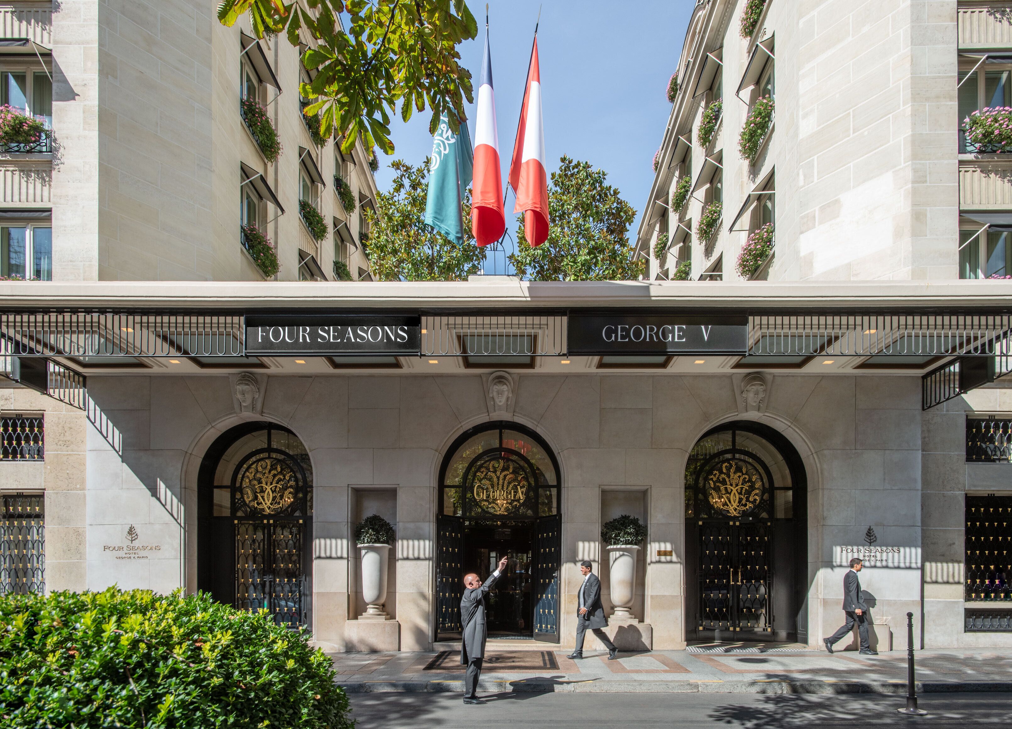 The exterior of the Four Seasons George V hotel with its grand entrance, flags, and classic architecture.