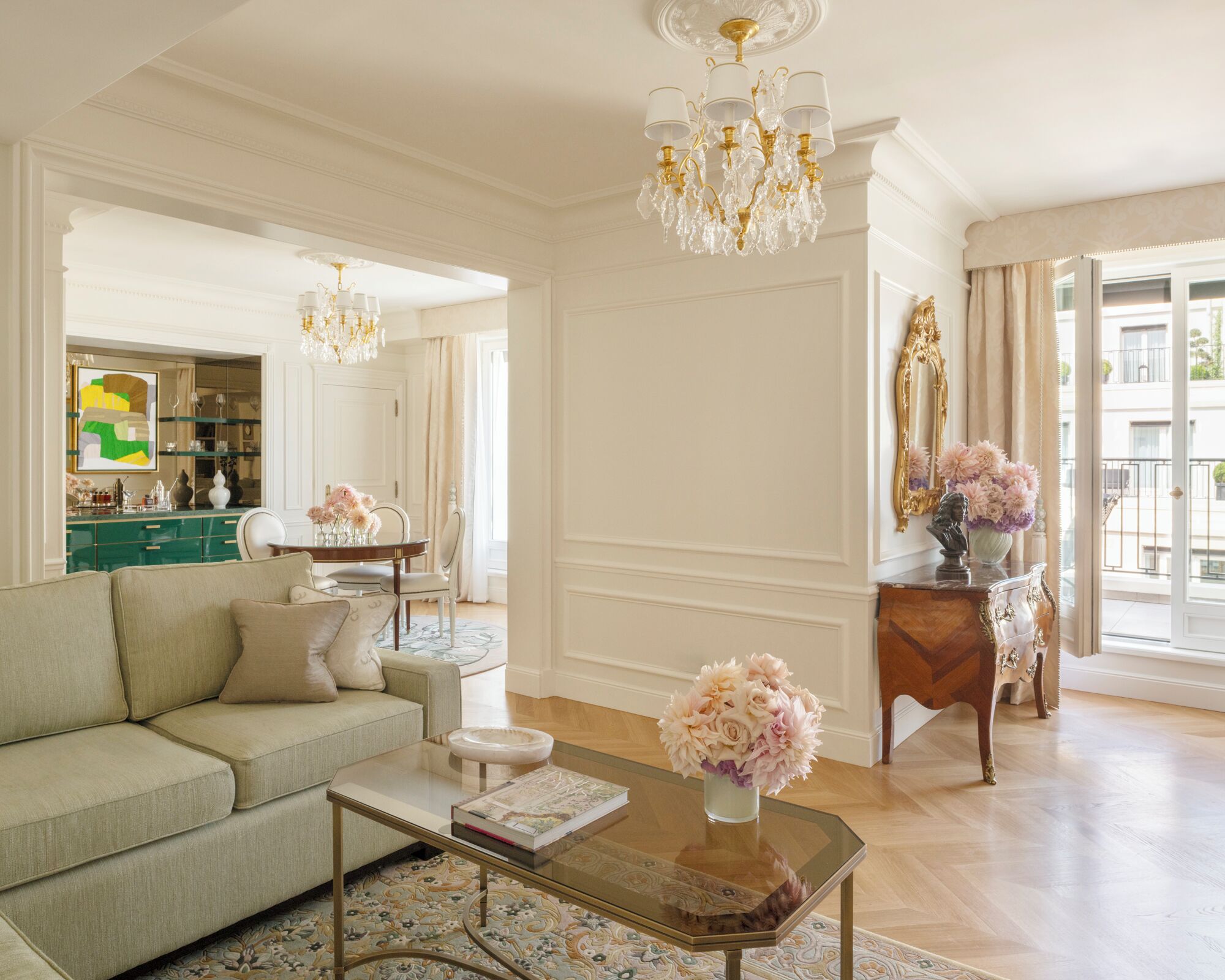 A spacious living room with a sofa, coffee table, and a chandelier.