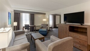 A hotel room with a sofa, armchairs, a TV, a desk, and a lamp. - Best Western Plus Toronto Airport Hotel (Mississauga)