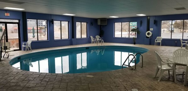 Una piscina cubierta, tumbonas