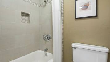 A bathroom with a bathtub, a toilet, and a shower.