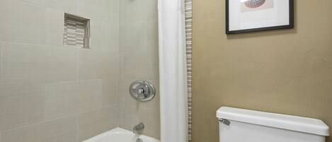 Ein Badezimmer mit Badewanne, Toilette und Dusche.
