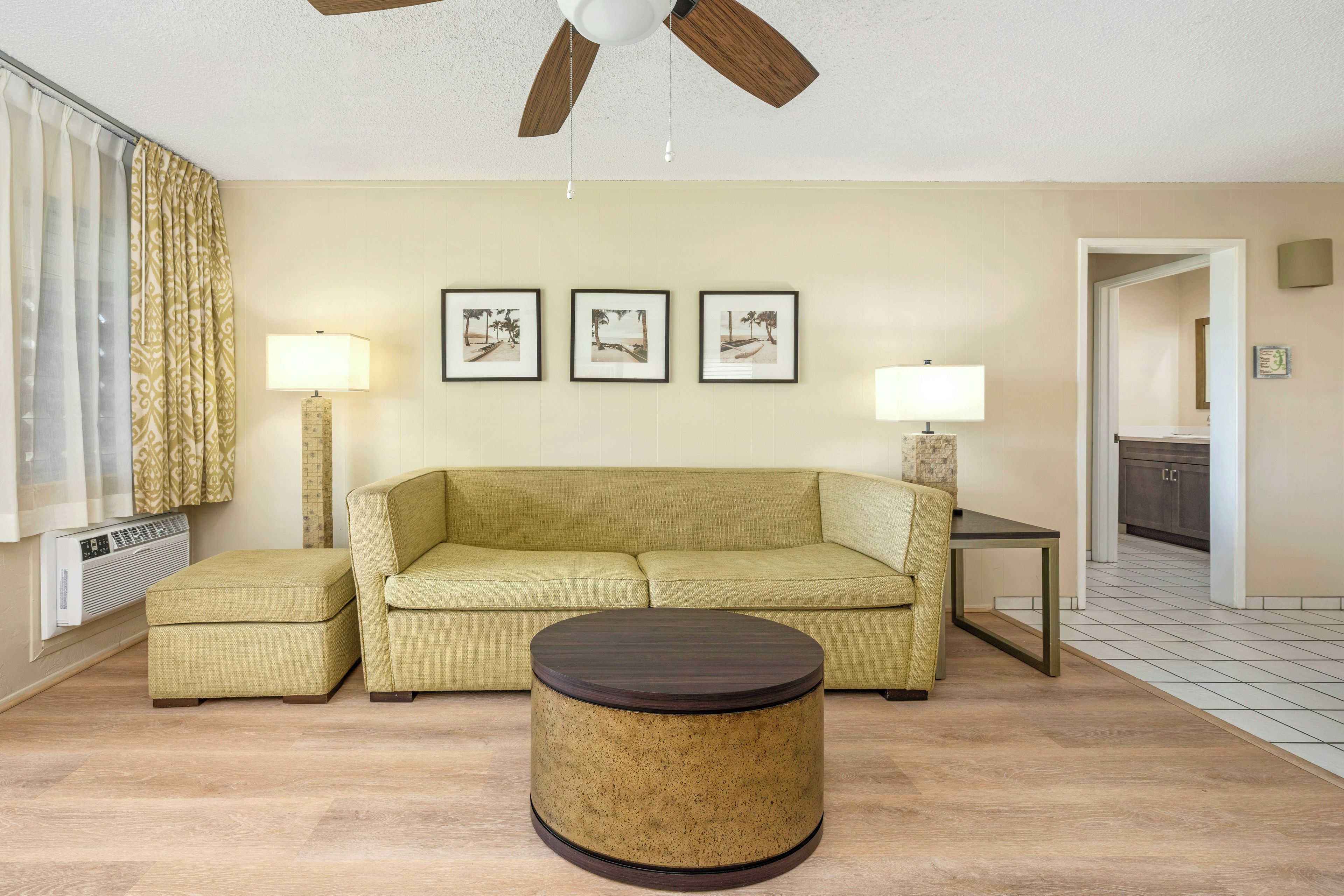 A living room with a sofa, a coffee table, and three framed pictures on the wall.