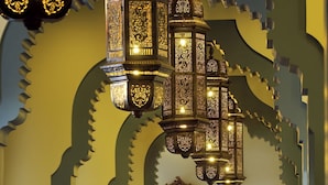 An ornate interior with traditional chandeliers, patterned carpet, and classic furniture.